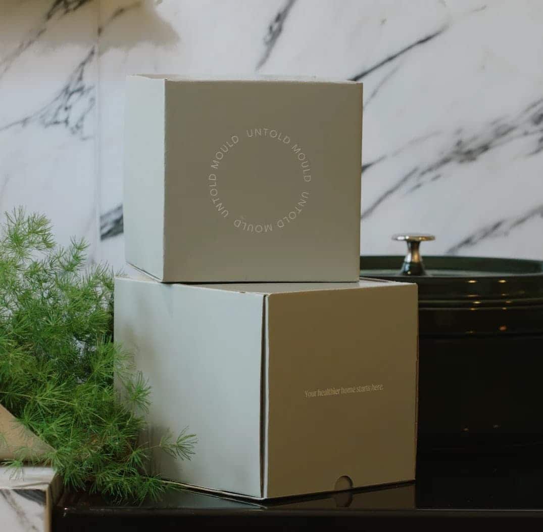 Two stacked boxes with 'Untold Mould' branding on a marble surface.